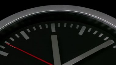 Siyah arka plan üzerinde izole edilmiş siyah bir duvar saatinin yakın çekim, on geçmiş on iki gösteren