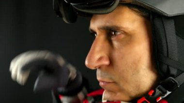Kayakçı/snowboard onun kask siyah arka plan üzerine tokalar, jest, yakın çekim kazanan yapar