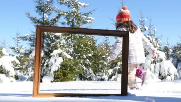 冬の雪の中で遊ぶ母と娘、前景のフレーム。フレーム内の画像は油塗装効果付き — ストック動画