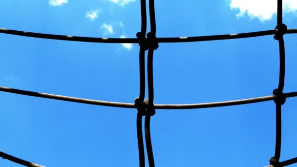 A boy is climbing on rope in playground. Recreation outdoors for kids — Stock Video