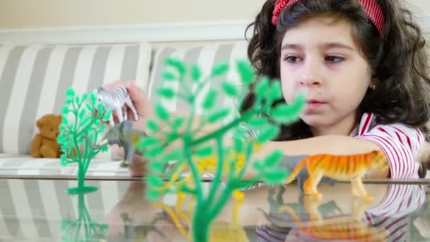 Close up de uma menina bonita brincando com brinquedos de animais em uma mesa, boneca — Vídeo de Stock