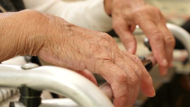 Yaşlı bir kadının bir koltuk değneği üzerinde el yakın çekim — Stok video