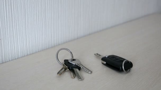 Man's hand throws the car and house keys on a table — Stock Video