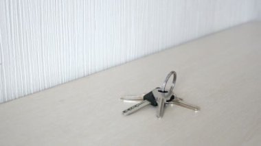 Kadın eli evin anahtarları bir tablodan alır