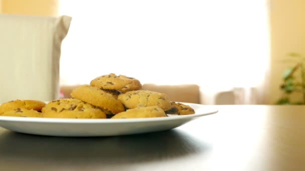 Niña secretamente toma una galleta de un plato en una mesa — Vídeos de Stock