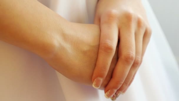 Bride's hands clasp in front of a wedding dress — Stock Video