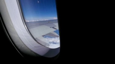 Uçak pencere görünümüne mavi gökyüzü ve bulutlar. Ulaşım