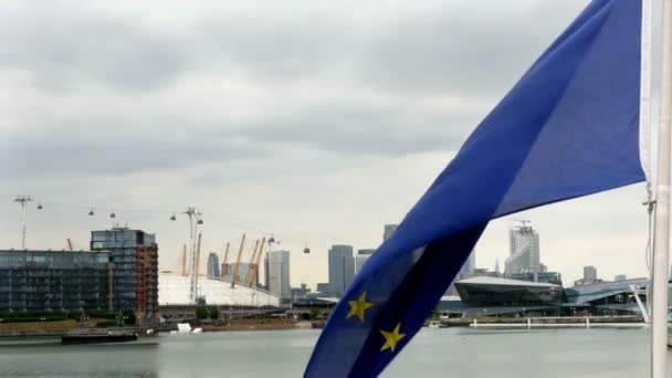 Europeiska unionens flagga vajande i vinden, Canary Wharf, London i ryggen — Stockvideo