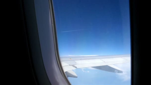 Vliegtuig venster uitzicht op de blauwe hemel en wolken. Vervoer — Stockvideo