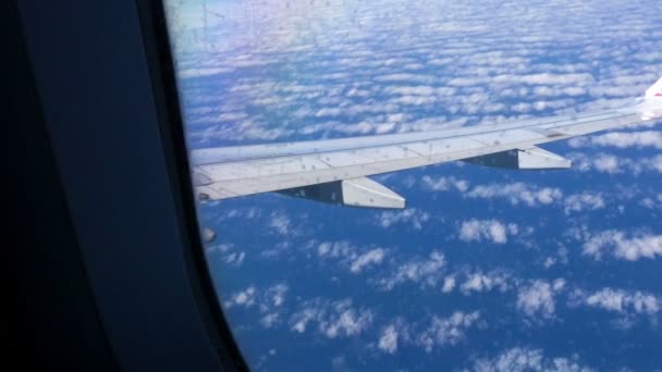 Vista del finestrino dell'aereo verso il cielo blu e le nuvole. Trasporti. — Video Stock