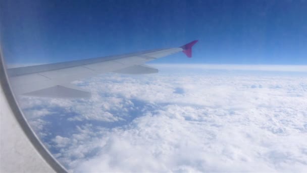 Αεροπλάνο παράθυρο με θέα προς το γαλάζιο του ουρανού και τα σύννεφα. Μεταφορά — Αρχείο Βίντεο
