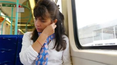 Londra 'da tren yolculuğu yaparken akıllı telefon kullanan bir kadın.