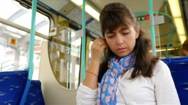 Londra 'da tren yolculuğu sırasında akıllı telefon kullanan bir kadın.