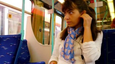 Londra 'da tren yolculuğu sırasında akıllı telefon kullanan bir kadın.