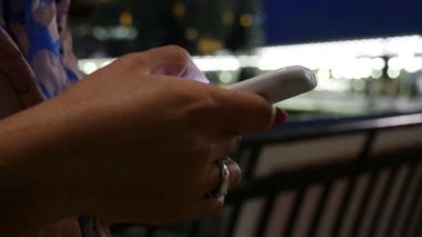 Canary Wharf ve London, içinde geceleri akıllı telefon kullanan kadın sadece eller