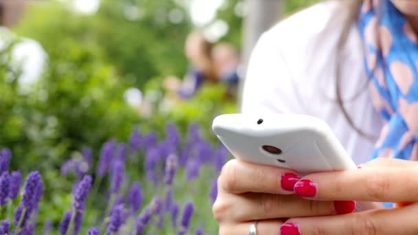 Femme utilisant un téléphone intelligent alors qu'elle était assise dans un parc à Londres, mains seulement 
