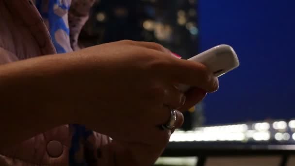 Woman using smart phone at night in Canary Wharf, London, hands only — Stock Video