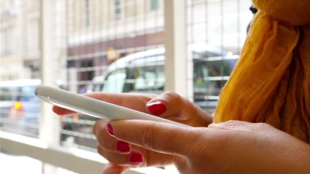 Mulher usando telefone inteligente em uma rua em Londres, veículos em segundo plano, mãos apenas — Vídeo de Stock