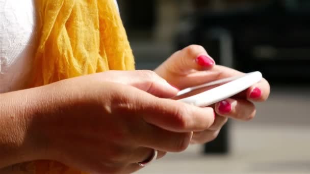 Vrouw met behulp van slimme telefoon op een straat in Londen, voertuigen op de achtergrond, handen alleen — Stockvideo