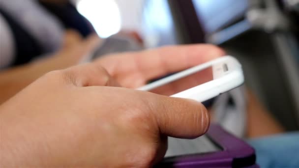 Mulher usando telefone inteligente enquanto viaja em um avião — Vídeo de Stock