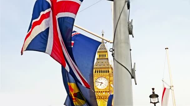 Vista del Big Ben, Londres vista a través de banderas de naciones de la Mancomunidad ondeando en el viento — Vídeo de stock