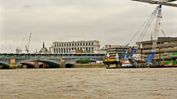 Visa till Londons silhuett från turbåt passerar under Millennium bridge — Stockvideo