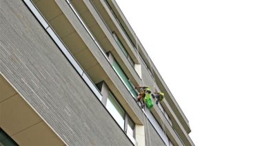 Londra 'da modern bir ofis tırpanının pencerelerini temizleyen işçiler.