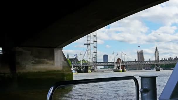 4K вид на Лондонське око, Біг-Бен і будівлі парламенту від рухомої човни на річці Темза — стокове відео