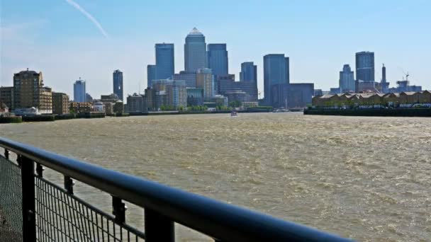 Barcos flotando en el río Támesis al atardecer, Londres, centro de negocios Canary Wharf al fondo — Vídeos de Stock