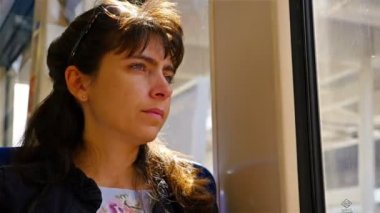 Hareket eden bir trenin içinde oturan ve Londra, İngiltere dışında arayan kadın