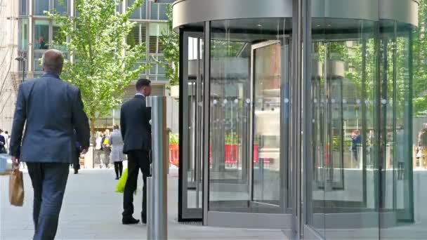 Verenigd Koninkrijk, Londen-14 juni 2015: zakenlieden lopen in en uit een modern kantoorgebouw in Londen City, Engeland — Stockvideo