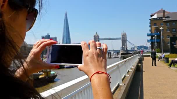 Mujer turista tomando fotos de Tower Bridge y el fragmento en la ciudad de Londres, Reino Unido — Vídeos de Stock
