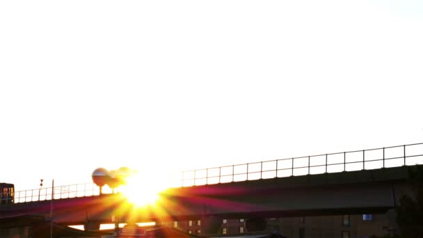 Verenigd Koninkrijk, Londen - 15 juni 2015: Silhouet van een trein verplaatsen over een brug in een woonwijk van London, Verenigd Koninkrijk. Zonsondergang. — Stockvideo