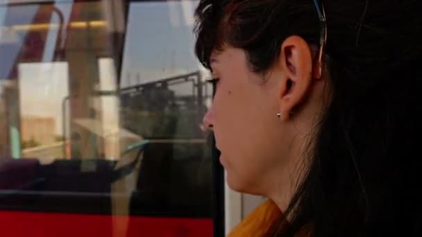 Mujer sentada en un tren, mirando otro tren que pasa por Londres, Reino Unido — Vídeos de Stock