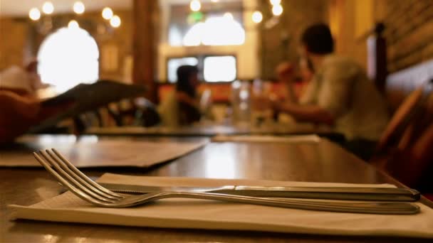 Cena en un restaurante. Grupo de personas comiendo y hablando. Comida gourmet. Cuchillo y tenedor en el frente — Vídeos de Stock