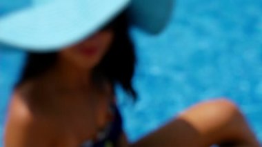 Bir takim elbisesi ve bir yüzme havuzu ve cep telefonu ile kendini alarak fotoğraf kenarında oturan mavi Yüzme içinde genç kadın