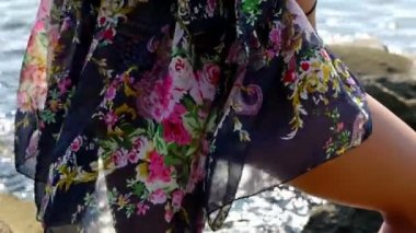 Renkli yaz aylarında genç kadın elbise kayalık sahilde deniz hayran