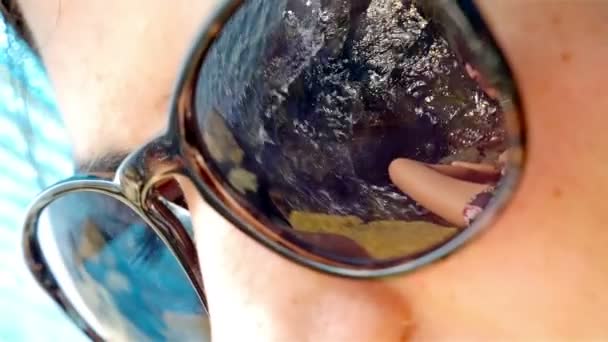 Sea rocks reflect in a sunglasses of female face — Stock Video