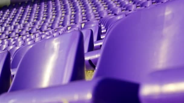 Rijen van violet plastic stoelen op de tribune van het stadion, dolly — Stockvideo