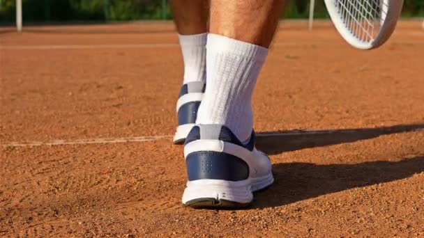 A lábak szolgáló tenisz labda, tenisz ütő a agyag bíróság teniszező — Stock videók