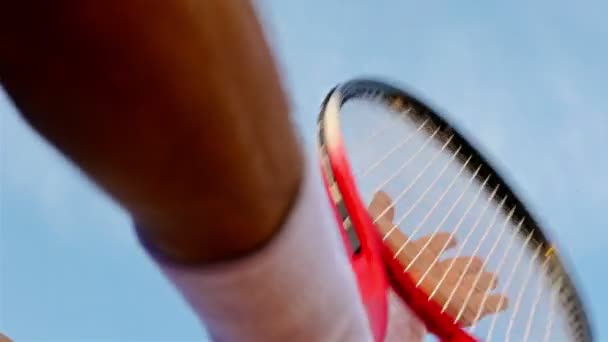 Primo piano della mano di una tennista che colpisce la rete della sua racchetta da tennis contro il cielo blu — Video Stock