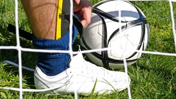 Fotbollsspelare kopplingsförbehåll fotboll stövlar förbereder sig för en fotbollsmatch fotboll — Stockvideo