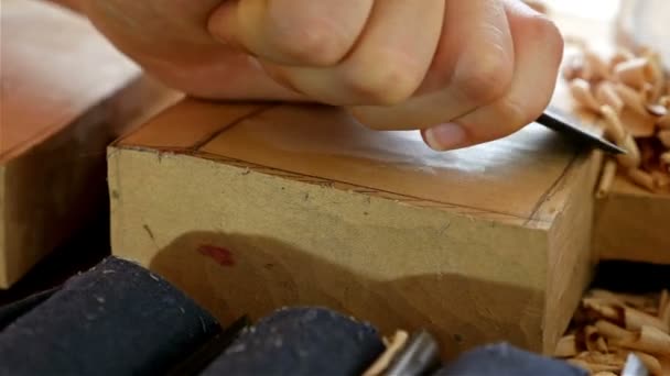 Резьба по дереву - человеческая рука, вырезающая кусок дерева — стоковое видео