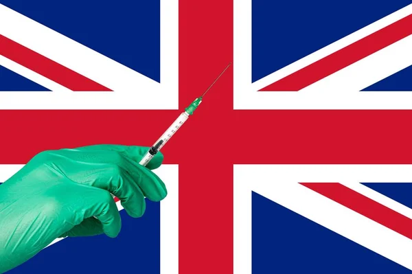 Vacunación con corona frente a una bandera del Reino Unido — Foto de Stock
