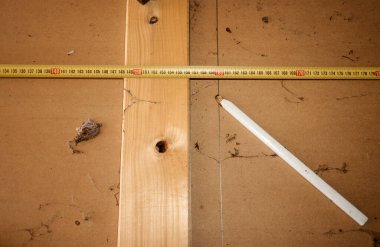 Çeşitli aletler, kalem ve mezura içeren ahşap bir tabak..