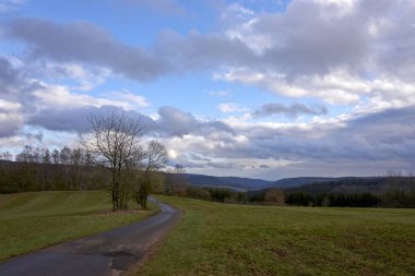 Almanya 'da bulutların, otların ve dağların manzarası, İlkbaharda Rhineland-Palatinate' de Vulkaneifel.