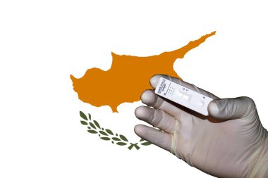 Kıbrıs Bayrağı önünde negatif antijenik korona testini gösteren bir el
