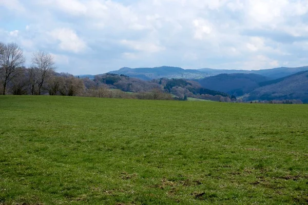 Almanya 'da bulutların, otların ve dağların manzarası, İlkbaharda Rhineland-Palatinate' de Vulkaneifel.