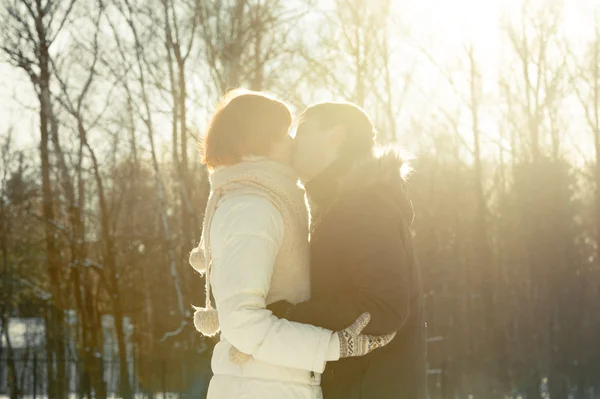 Пара поцелуев на фоне солнечного света в парке — стоковое фото
