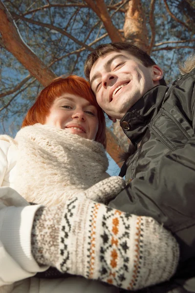 Feliz pareja sonriente en el parque de invierno bajo el árbol — Foto de Stock